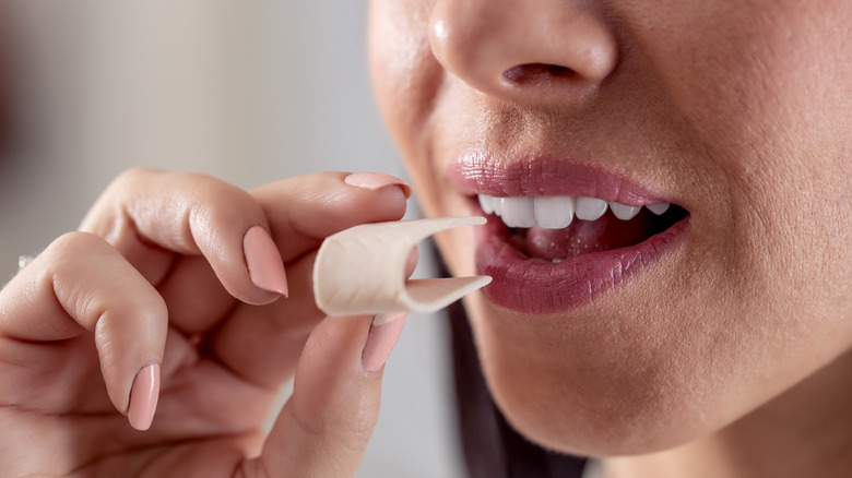 woman putting gum in mouth