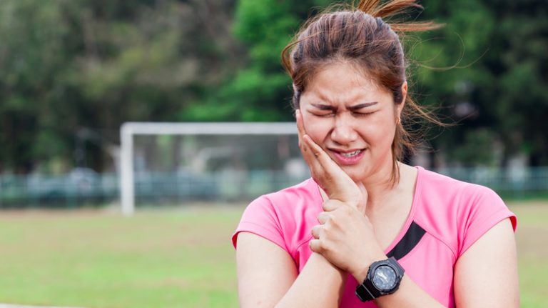 runner holding face in pain