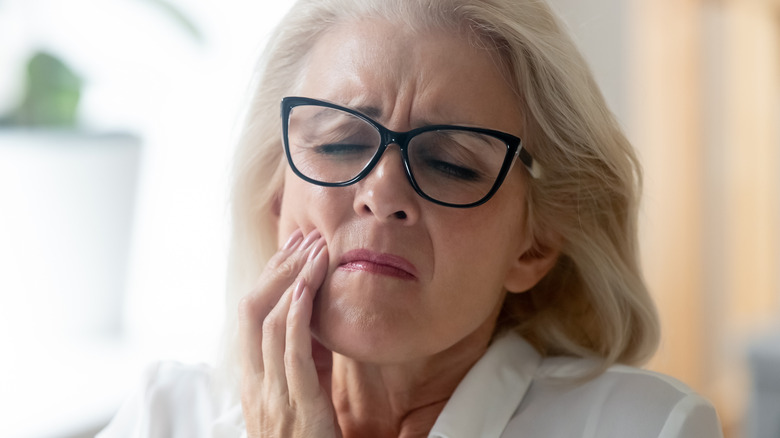 Older woman holding jaw