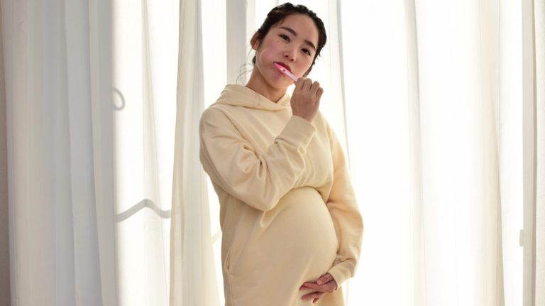 Pregnant person brushing teeth