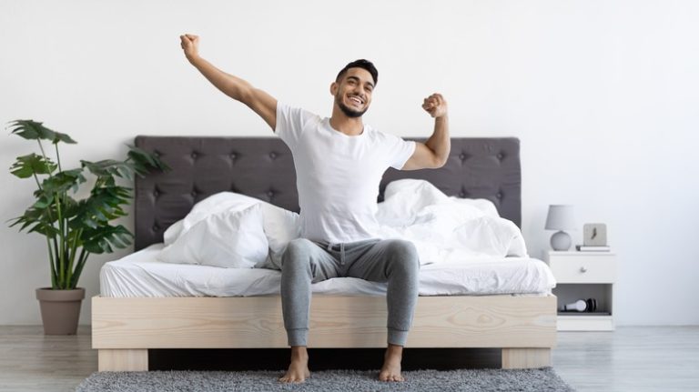 man stretching in bed