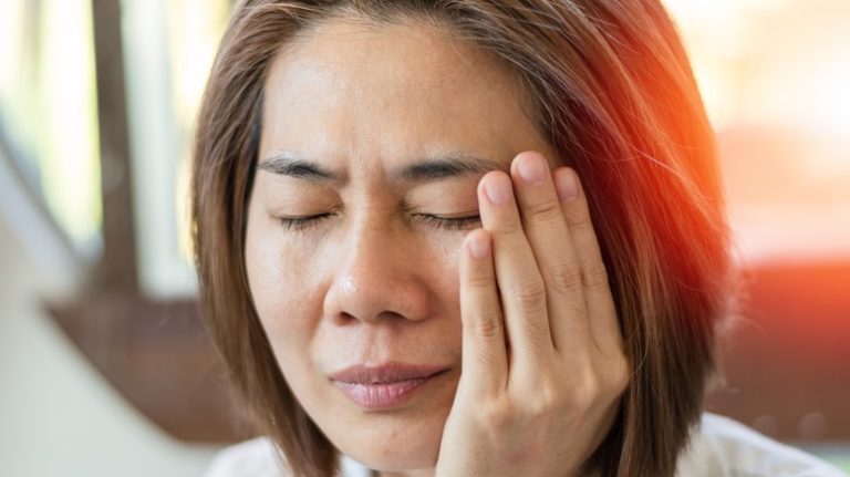 Woman holding jaw in pain