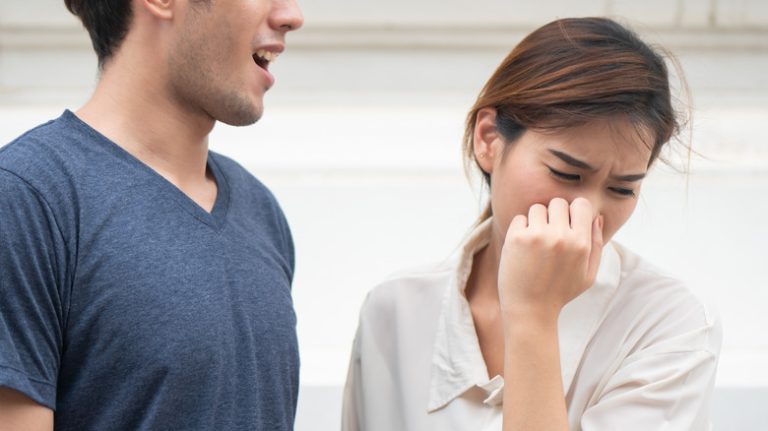 woman turning away from man with bad breath