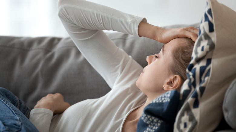 Depressed woman napping on couch