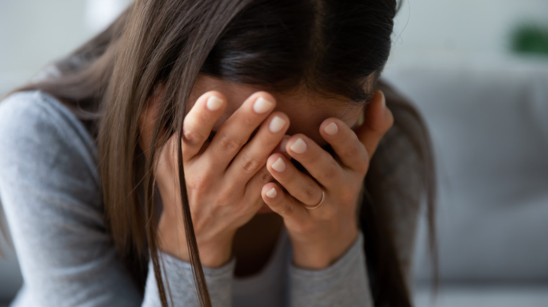 Woman covering face with hands