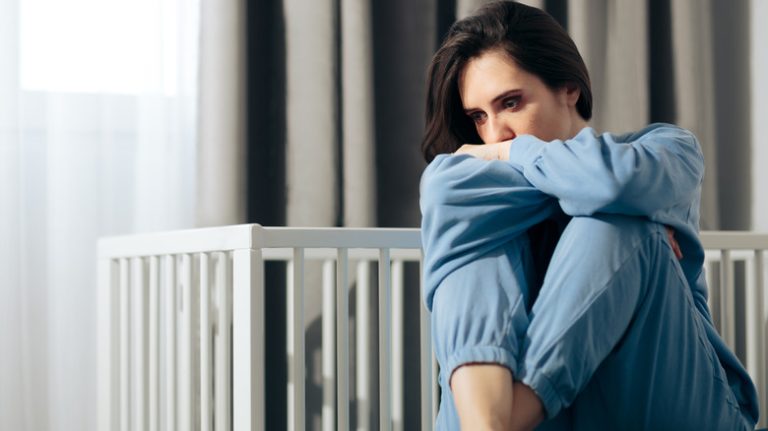 Woman sitting by crib