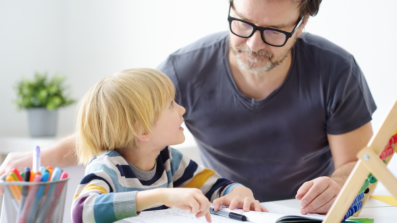 child with ADHD working with adult on schoolwork