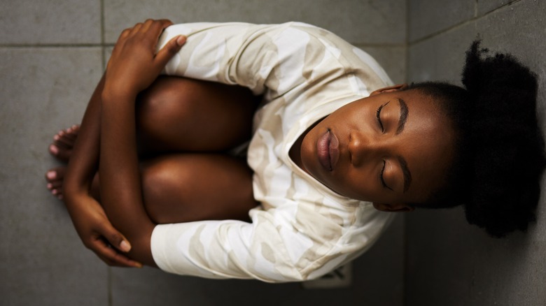 Woman breathing deeply holding knees