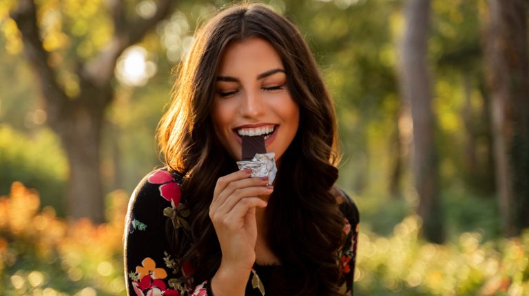 Woman smiling while eating chocolate