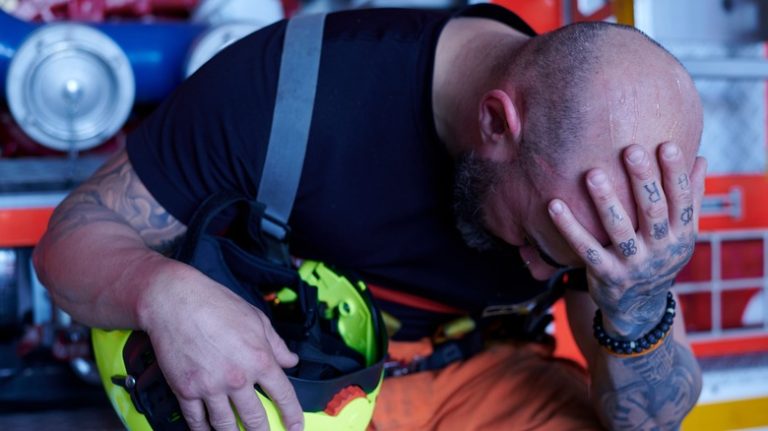 Distressed firefighter with head in hand