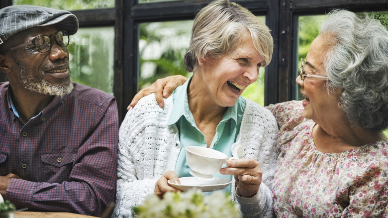 Smiling happy group of seniors drinking tea