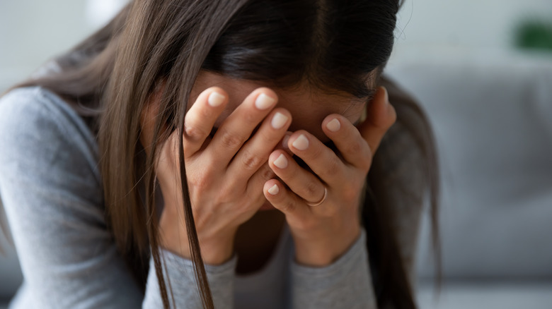 Close up of a woman hiding face in hands