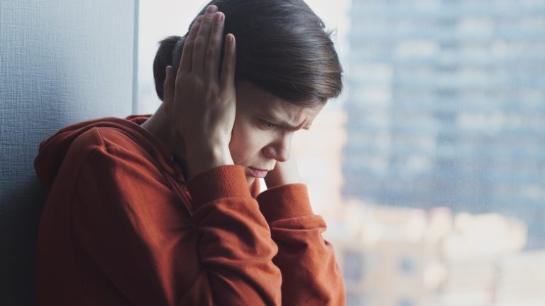 Distressed woman covering ears