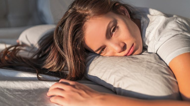 woman looking depressed in bed