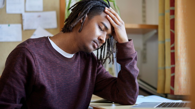 Stressed young man sitting at desk