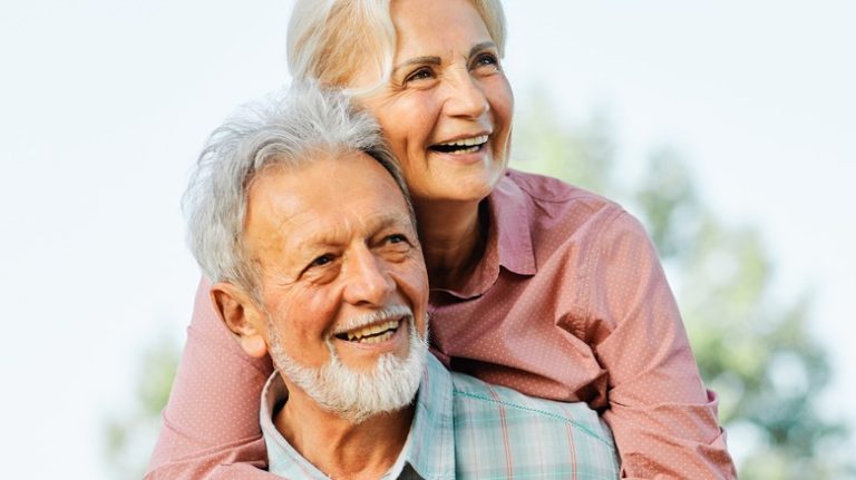 a happy older couple holding one another