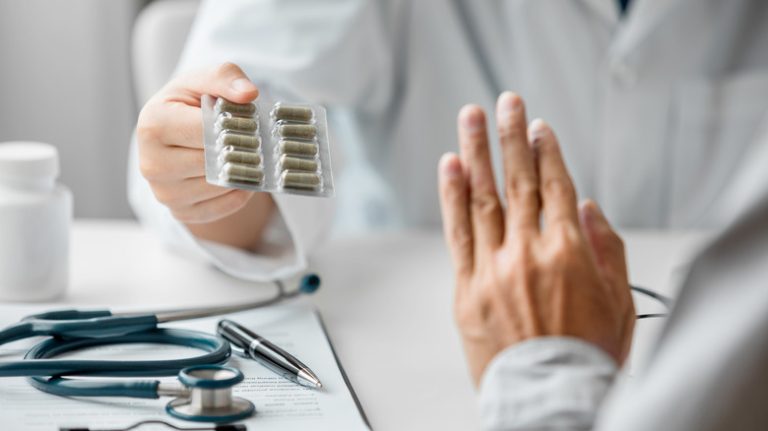 Patient holds up hand to refuse medication