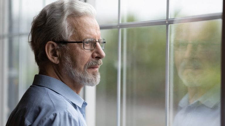 man looking out window