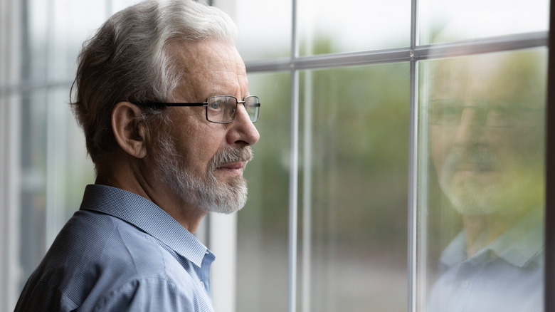 man looking out window