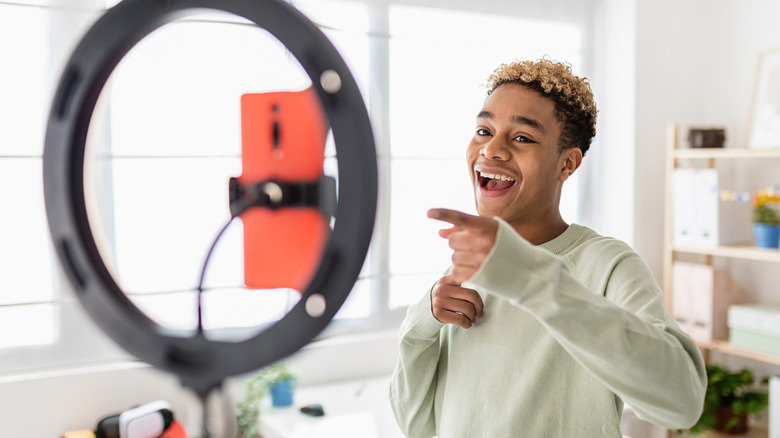 Smiling teen boy recording video