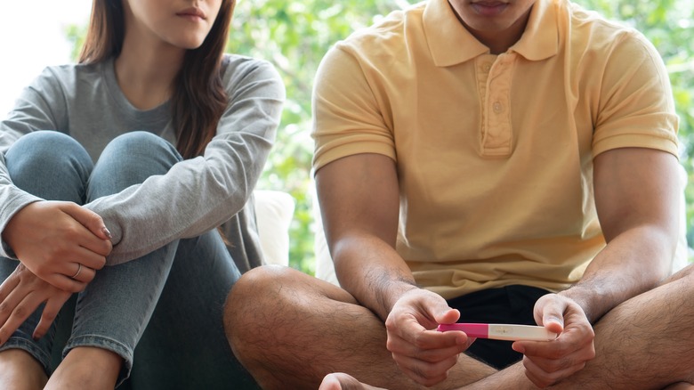 sad couple holding a pregnancy test