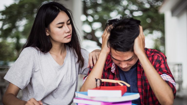 Concerned friend comforting distressed classmate