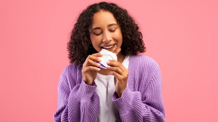 woman eating bar of chocolate