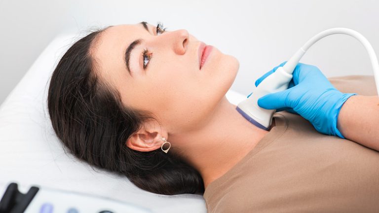 woman receiving thyroid exam