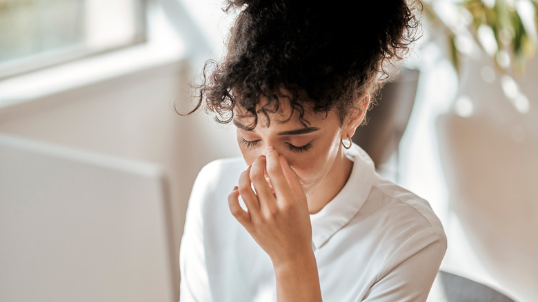 Stressed woman touching nose