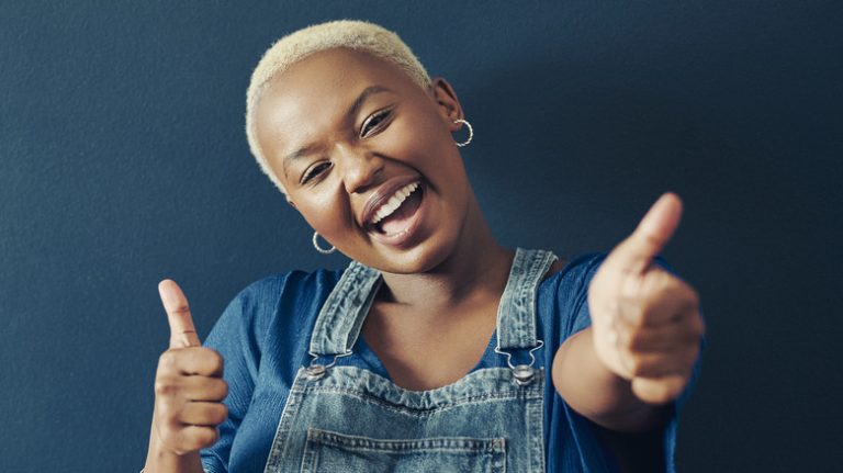 smiling woman giving two thumbs up