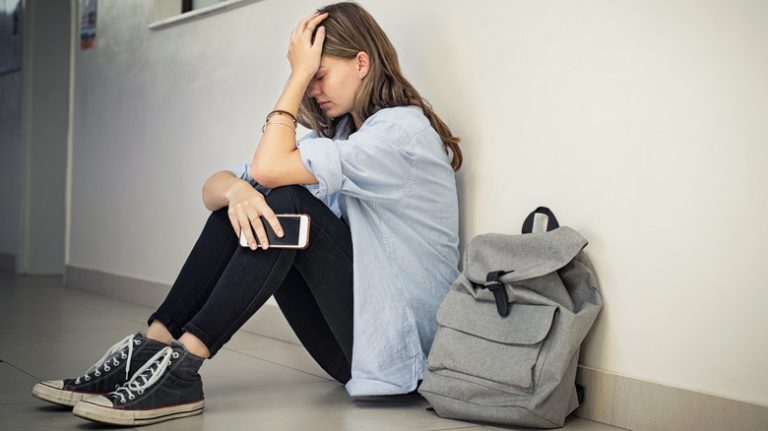 A distraught girl holds her head