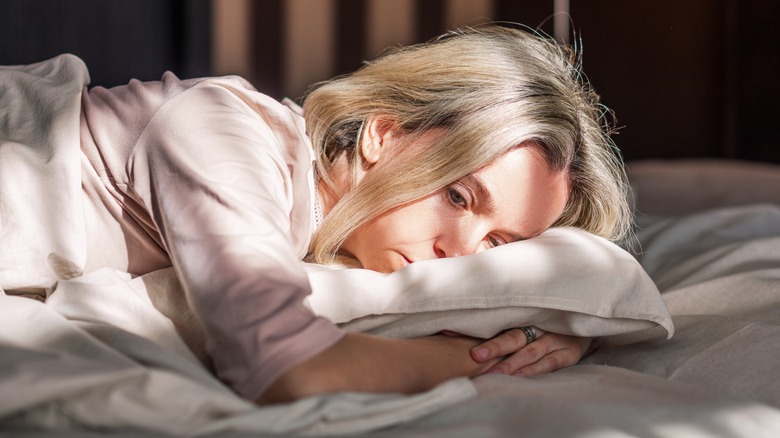 depressed woman lying in bed